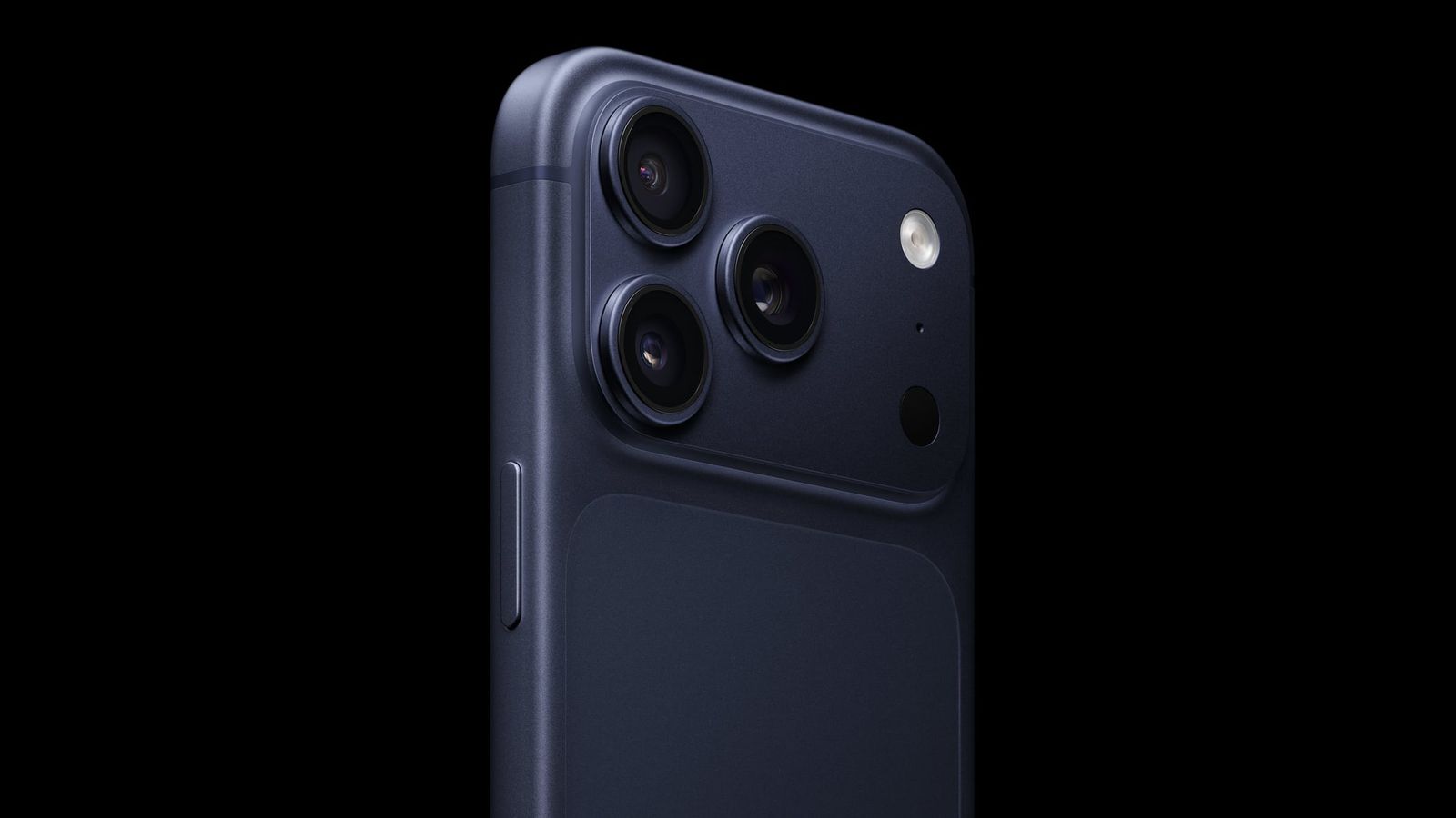 من موقع فون إسلام: لقطة مقرّبة لوحدة الكاميرا الخلفية على كاميرا خلفية بلون داكن، تبرز ثلاث كاميرات آيفون وفلاش على خلفية سوداء.