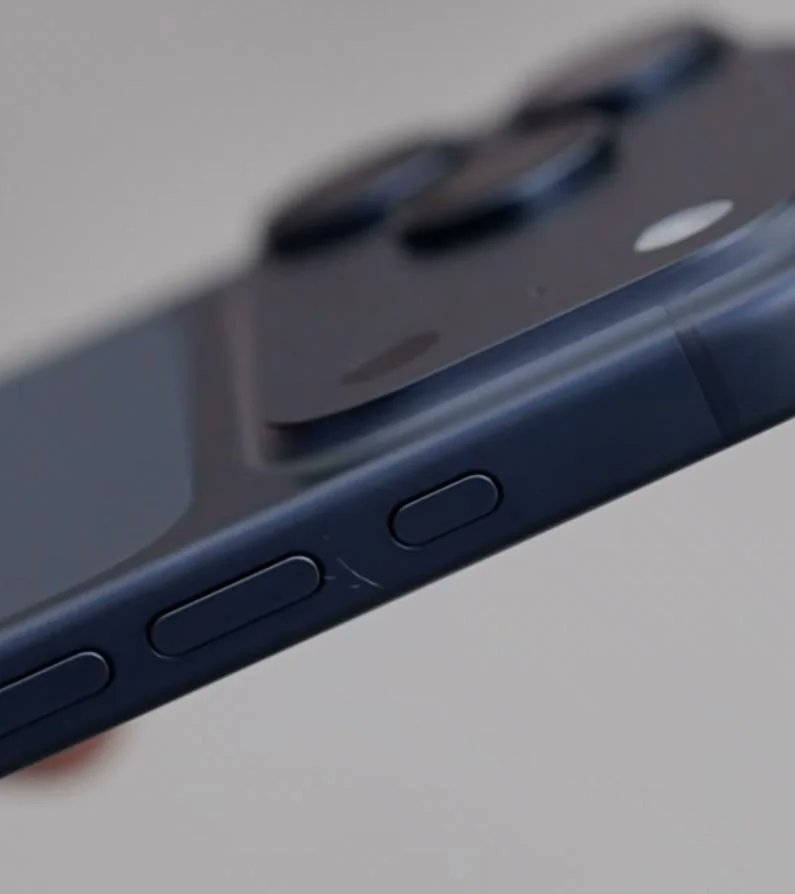 من موقع فون إسلام: منظر عن قرب لجانب الهاتف الذكي الأسود، على غرار الهاتف الذكي الذي يشاع أنه آي-فون 17، يظهر ثلاثة أزرار مادية وجزء من وحدة الكاميرا الخلفية - وهي تفاصيل أثارها بعض المستخدمين على أنها مشكلة تصميم.