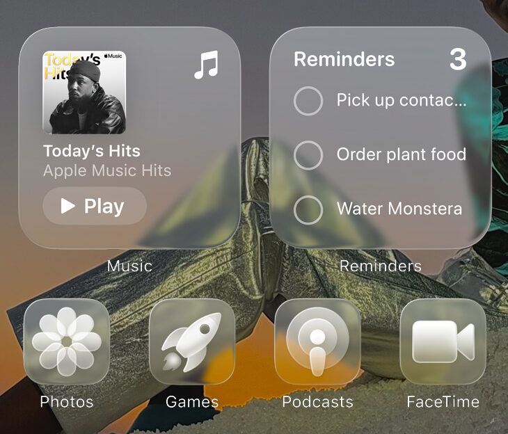 من موقع فون إسلام: تجلس امرأة ترتدي فستانًا منقوشًا على سطح أبيض عند غروب الشمس بينما يعرض تراكب الشاشة الرئيسية لنظام iOS 26 مع ميزات ذكية للموسيقى والتذكيرات وأيقونات التطبيقات في الأسفل.