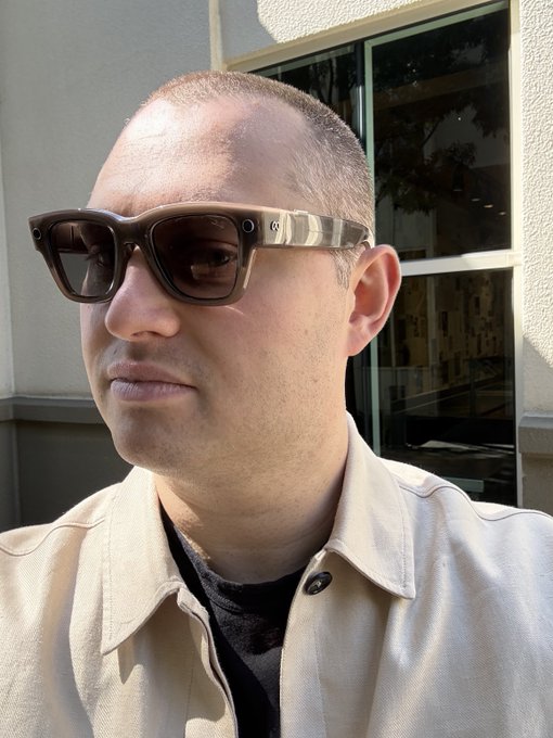 من موقع فون إسلام: يقف شخص يرتدي نظارة شمسية كبيرة داكنة اللون وسترة بيج اللون بياقة في الخارج بالقرب من نافذة في يوم مشمس في يوم مشمس في سبتمبر.