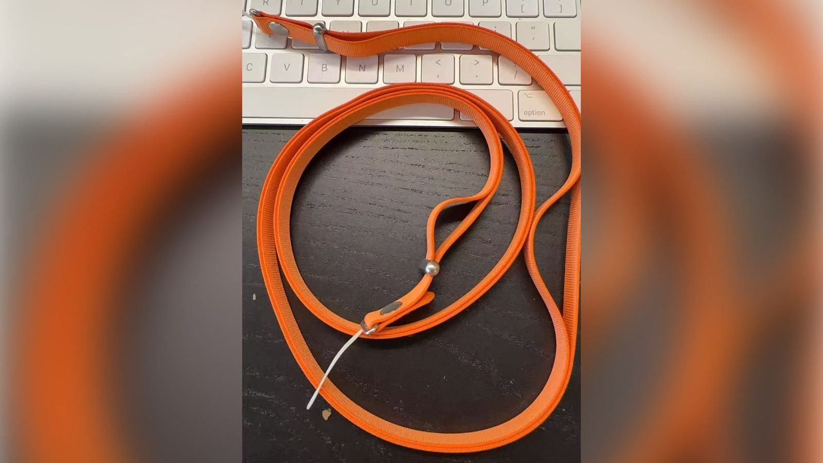 From Phone Islam: An orange steering wheel with a metal clip is wrapped on a black surface in front of a white computer keyboard, as rumors circulate about an upcoming Apple event regarding the iPhone 17.