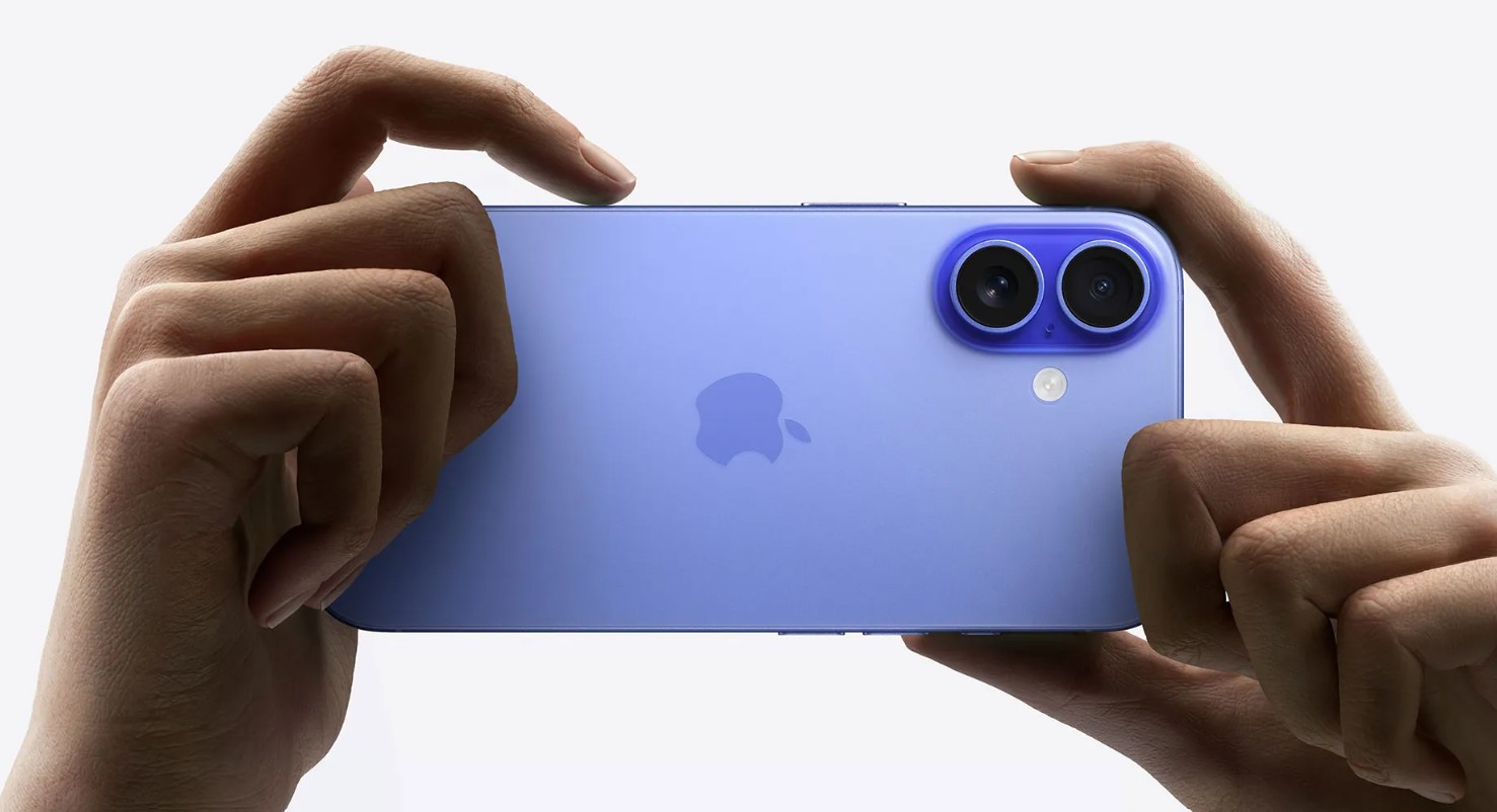 من موقع فون إسلام: يدان تحملان هاتفًا ذكيًا أزرق اللون بشكل أفقي، ويظهر على ظهره شعار Apple وكاميرتان خلفيتان - في إشارة إلى ميزات آي فون جديدة كما في آي فون 18 برو.