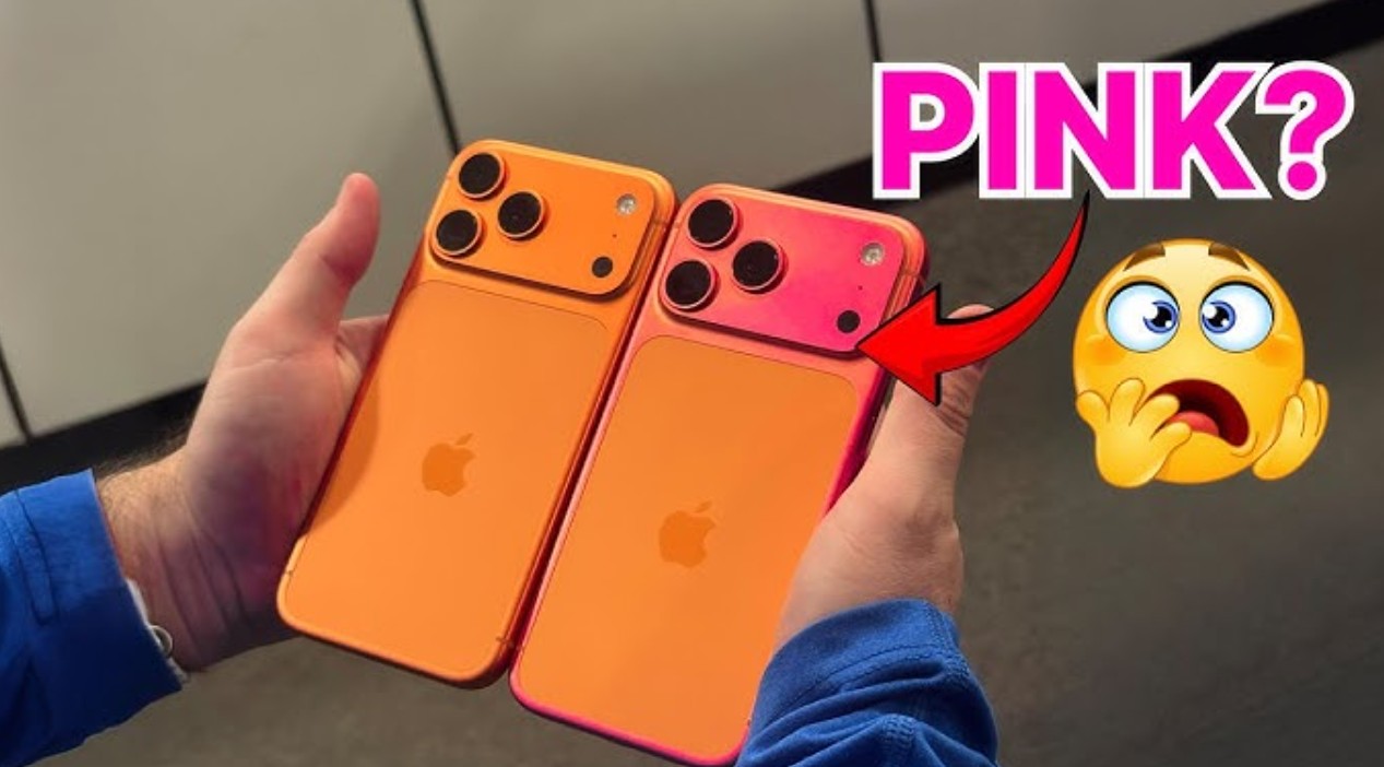 من موقع فون إسلام: يدان تحملان جهازي iPhone برتقالي ووردي جنباً إلى جنب، وسهم أحمر يشير إلى الهاتف الوردي مع رمز تعبيري لوجه متفاجئ فوقه "PINK?" ويظهر فوقه الرمز التعبيري "أي-فون 17 برو البرتقالي".