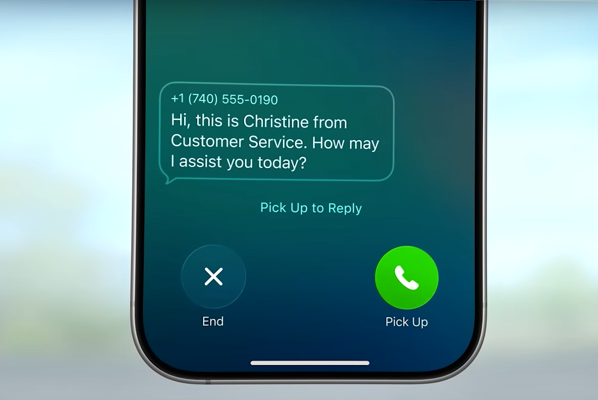 من موقع فون إسلام: تعرض شاشة الهاتف الذكي الذي يعمل بنظام iOS 26 مكالمة واردة مع رسالة: "مرحبًا، أنا كريستين من خدمة العملاء. كيف لي أن أساعدك اليوم؟" إلى جانب ميزة "إنهاء المكالمة" و"الرد على المكالمة" وميزة المساعدة في الانتظار الجديدة.