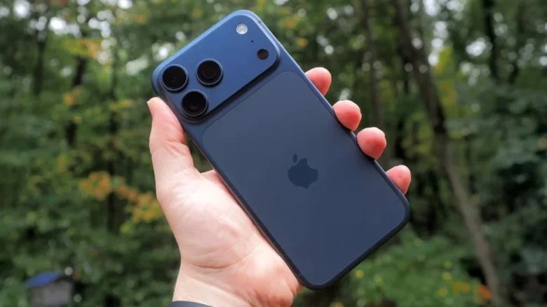 Da iPhone Islam: una mano che tiene un iPhone 17 blu con tre obiettivi per la fotocamera sul retro, all'aperto con alberi sullo sfondo, mette in mostra il suo design elegante e le sue funzionalità avanzate tra i problemi comuni.