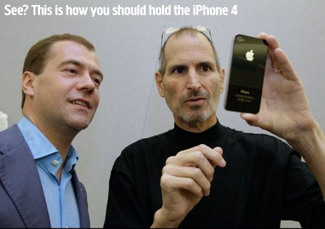 Da Phone Islam: Steve Jobs mostra a un altro uomo come tenere un iPhone 4, con un testo in alto che dice: "Vedi? Ecco come dovresti tenere un iPhone 4". Con un testo in alto che dice: "Vedi?