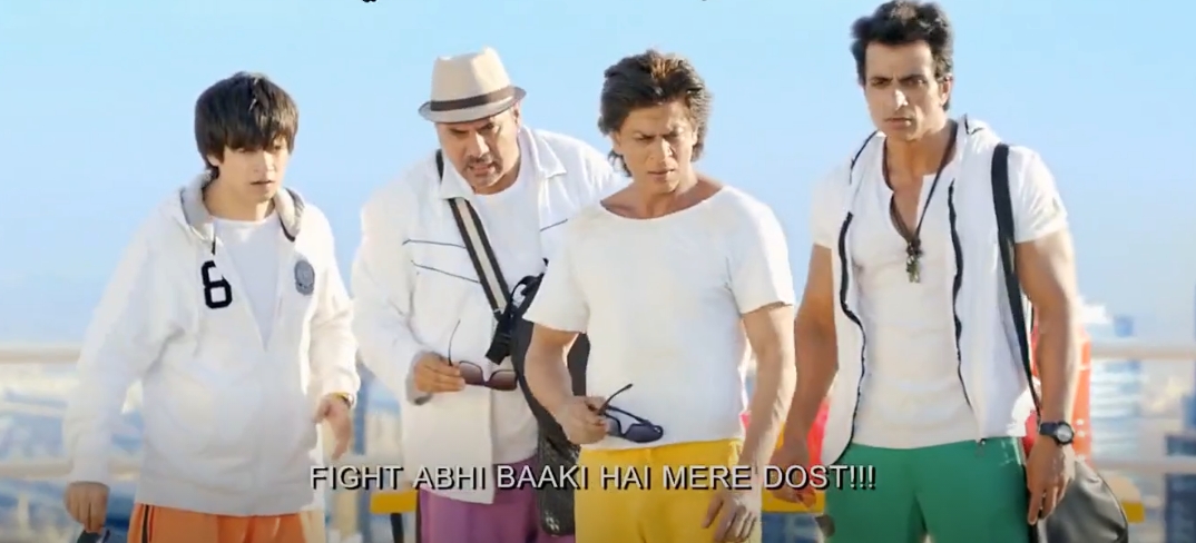 من موقع فون إسلام: أربعة رجال يرتدون ملابس غير رسمية يقفون معًا في الهواء الطلق، ويتطلعون إلى الأمام بجدية، بينما تُقرأ الترجمة الإنجليزية "FIGHT FIGHT ABHI BAAKI HAI MERE DOST!!!" - وهي لحظة يمكن أن تتماشى بسهولة مع عصر الهواتف الذكية.