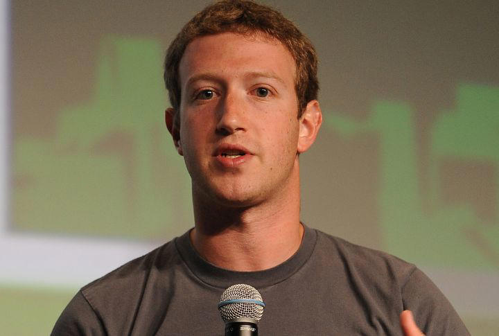 من موقع فون إسلام: رجل ذو شعر بني قصير يتحدث في ميكروفون عن التكنولوجيا ويرتدي قميصًا رماديًا سادة ويقف على خلفية غير واضحة.