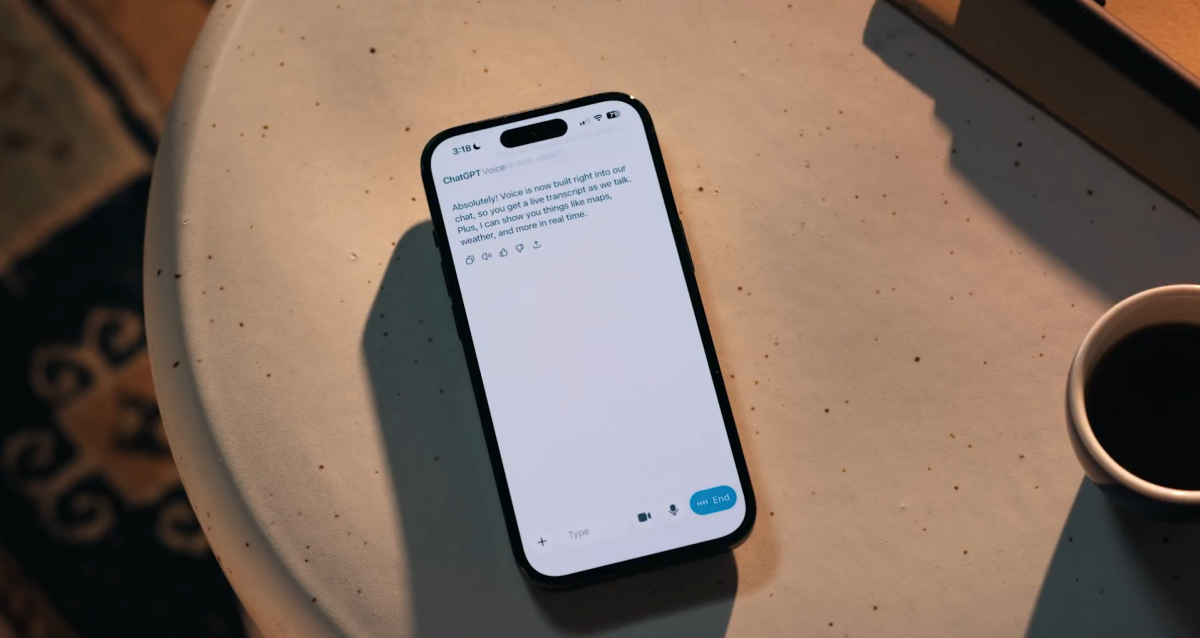 من موقع فون إسلام: هاتف ذكي على طاولة مستديرة يعرض محادثة نصية، إلى جانب جزء من فنجان به مشروب غامق. يوحي المشهد بمتابعة أخبار التقنيات أو أخبار على الهامش للاسبوع 21 - 27 نوفمبر أثناء استراحة لتناول القهوة.