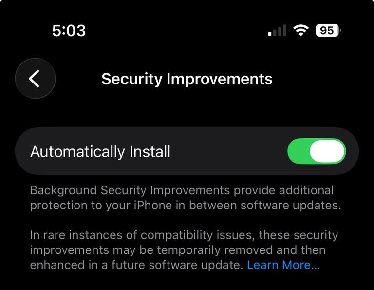 من موقع فون إسلام: شاشة هاتف آيفون تظهر إعدادات "تحسينات الأمان" مع تمكين تبديل "التثبيت التلقائي"، مع تسليط الضوء على كيفية تحديثات آيفون وميزات iOS 26.1 توفر تحديثات أمان تلقائية وتوافق أفضل للجهاز.