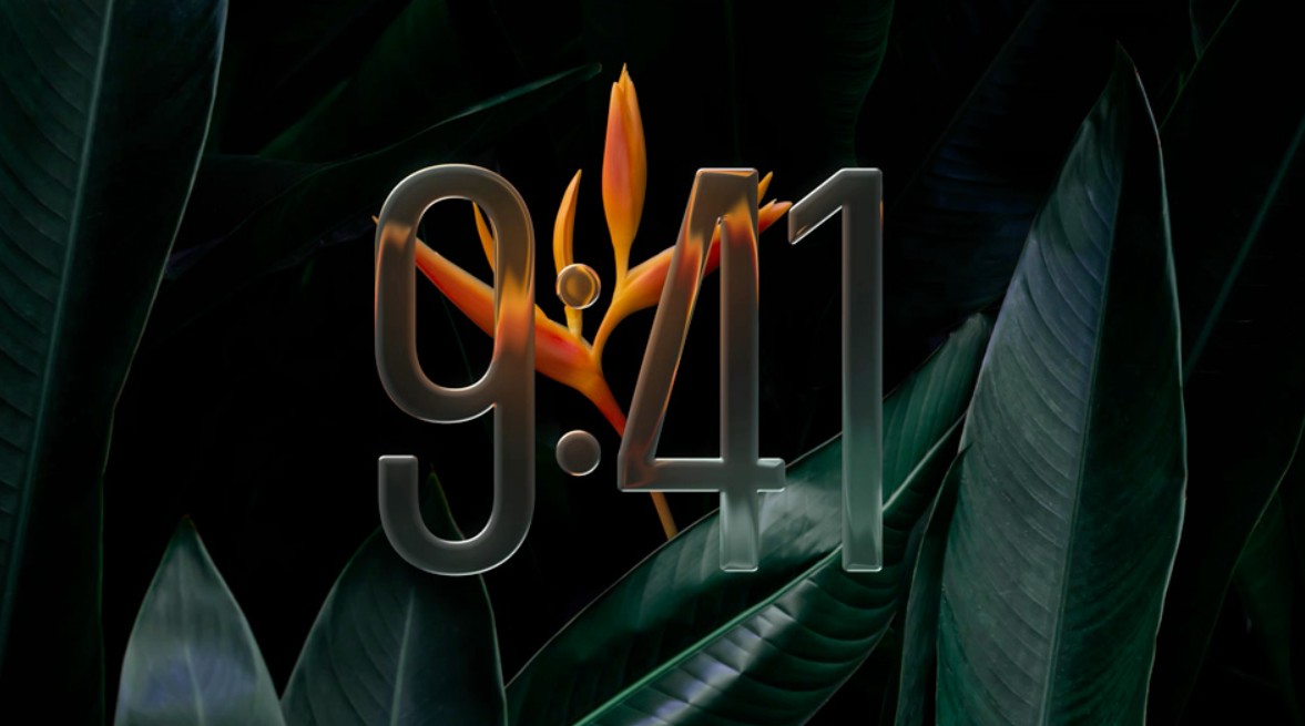 من موقع فون إسلام: تعرض الأرقام الشفافة الكبيرة الوقت "9:41" على خلفية من الأوراق الخضراء وزهرة استوائية برتقالية اللون، مما يعكس جودة التصميم والأداء الموجود في نظام التشغيل iOS 27.