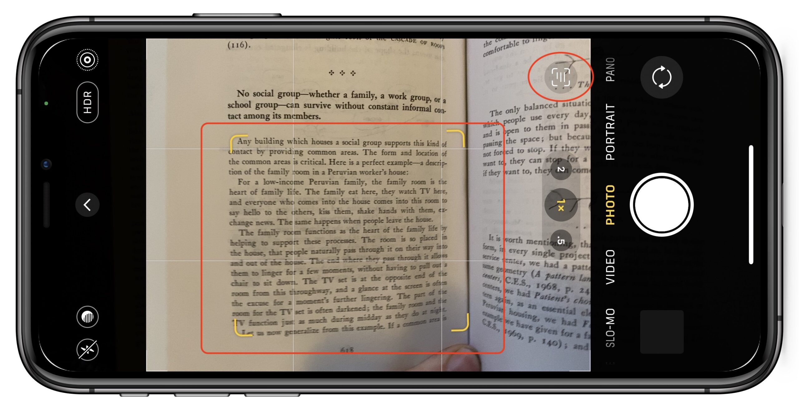 من موقع فون إسلام: تُستخدم كاميرا الهاتف الذكي في الآي-فون لمسح صفحة كتاب ضوئيًا. تعرض شاشة الهاتف واجهة الكاميرا والنص الذي يتم التركيز عليه داخل إطار أصفر، مع إبراز ميزات ذكاء اصطناعي للتعرف الفوري.