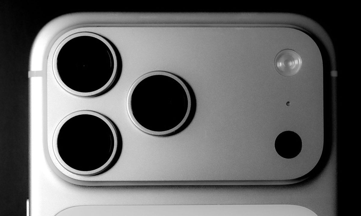 من موقع فون إسلام: صورة عن قرب لوحدة الكاميرا الخلفية لجهاز iPhone 17 Pro، تظهر ثلاث عدسات كاميرا وفلاش على سطح معدني، مع تسليط الضوء على البوريتري في الإضاءة الليلية الإضاءة الليلية.