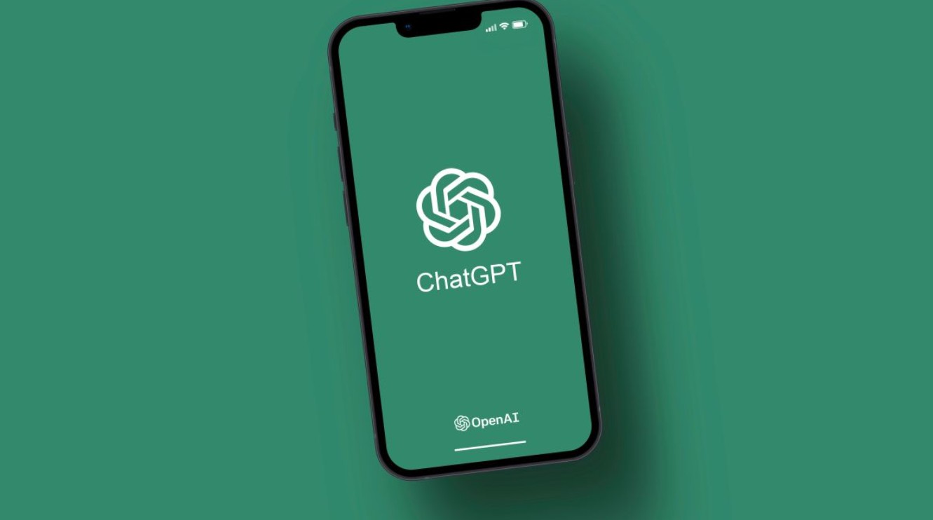 من موقع فون إسلام: يعرض الهاتف الذكي شاشة البداية لتطبيق ChatGPT مع شعار OpenAI على خلفية خضراء، ويعرض إعلانات ChatGPT في واجهة حديثة.