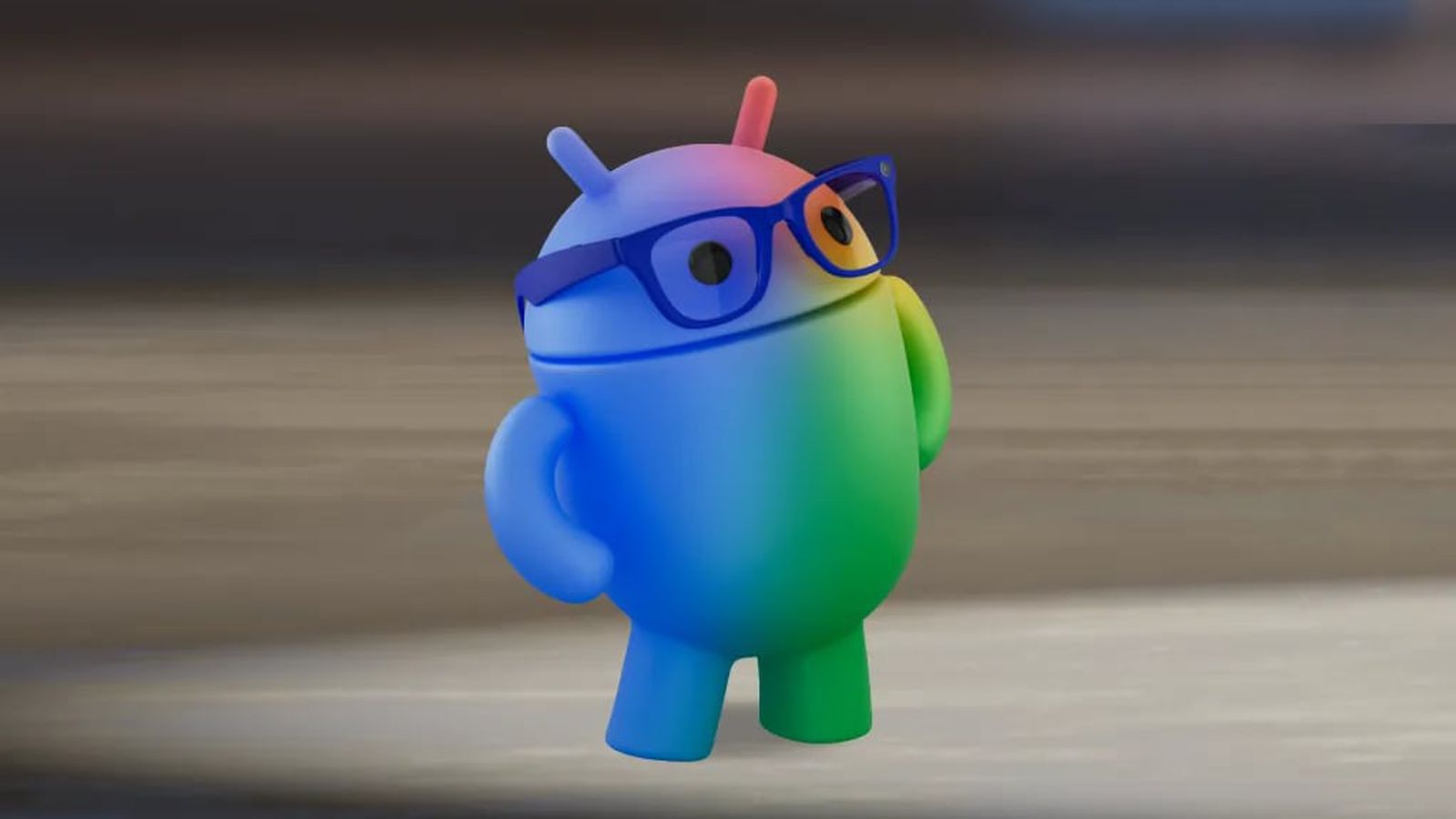 من موقع فون إسلام: مجسم تميمة أندرويد ثلاثي الأبعاد متدرج الألوان بألوان قوس قزح يرتدي نظارة زرقاء على خلفية محايدة.