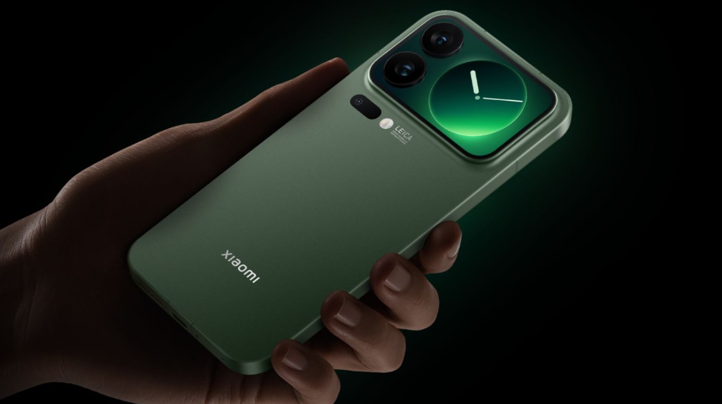 من موقع فون إسلام: يد تحمل هاتفًا ذكيًا أخضر اللون من شاومي مزودًا بوحدة كاميرا وشعار لايكا ظاهرًا على ظهره، وهو ما يقدم بديلاً أنيقًا لهاتف آي-فون إير.