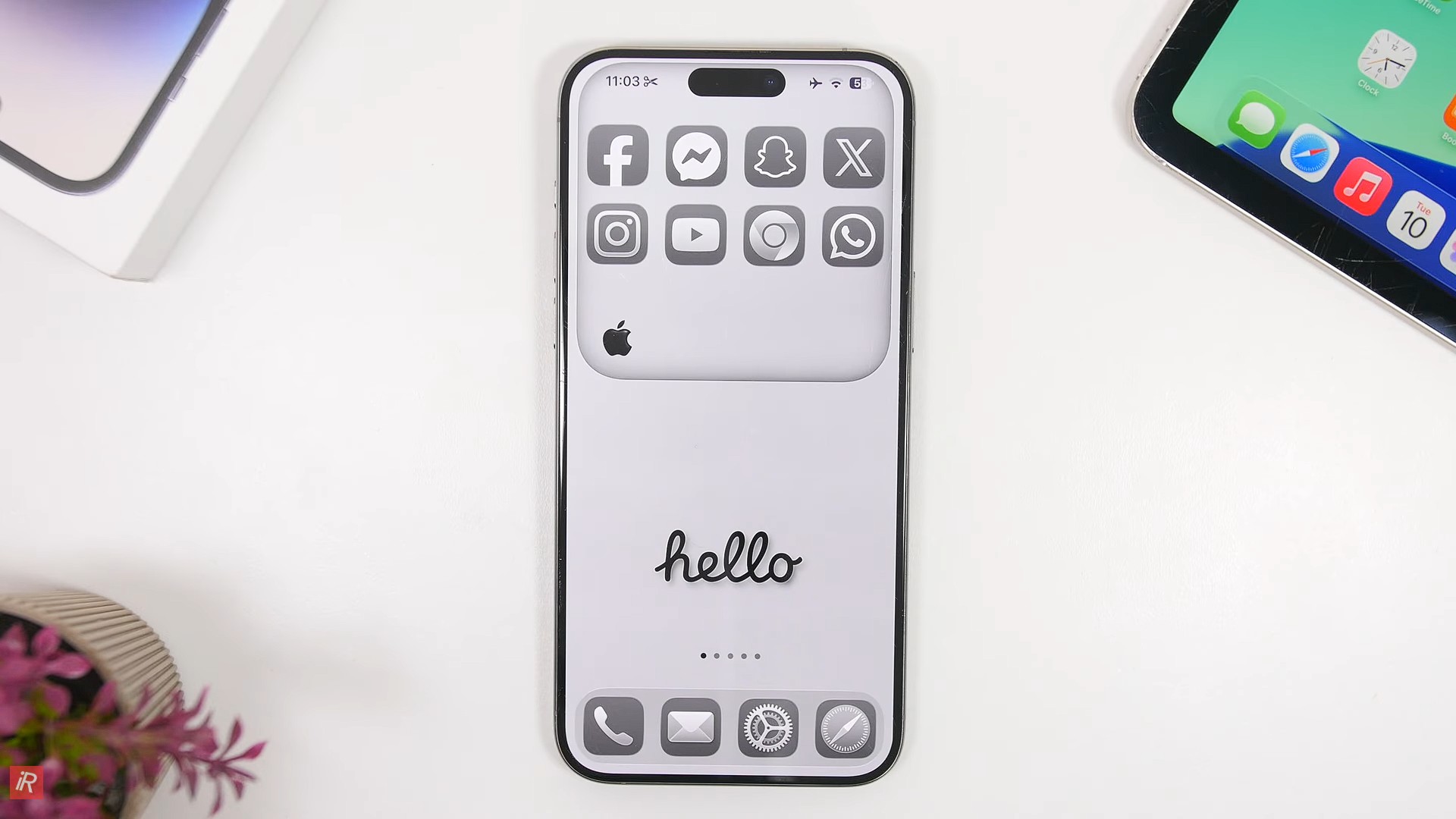 من موقع فون إسلام: يتميز هاتف آي-فون 17 الأنيق بشاشة رئيسية أنيقة وبسيطة باللونين الأبيض والأسود تعرض أيقونات تطبيقات التواصل الاجتماعي وكلمة "مرحبًا" بخطّ مكتوب في الوسط السفلي، مما يبرز البساطة الأنيقة والذكاء في نظام iOS.