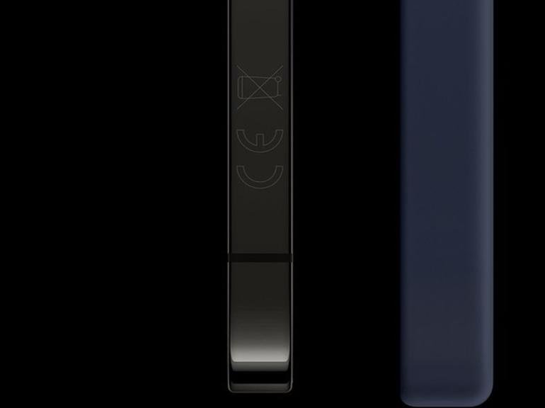 من موقع فون إسلام: صورة مقرّبة لحواف جهازين إلكترونيين مستطيلين جنباً إلى جنب، أحدهما أسود والآخر أزرق داكن, مع تسليط الضوء على الفرق بين الآي-فون الأمريكي والآي-فون الأوروبي مع رموز تنظيمية مرئية على الجهاز الأسود.