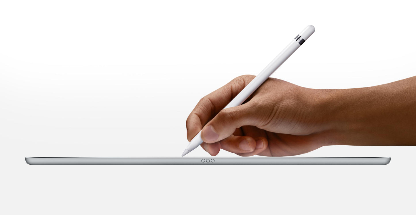 Ze strony internetowej PhoneIslam: Dłoń trzymająca Apple Pencil unosi się nad cienkim tabletem leżącym na białej powierzchni.