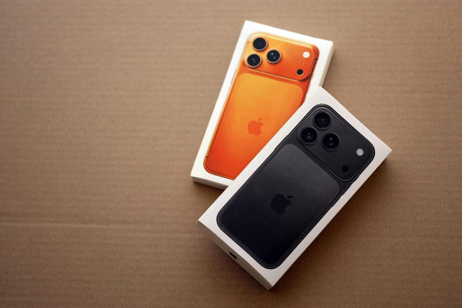 من موقع فون إسلام: تم وضع جهازي آيفون في صندوقين، أحدهما برتقالي والآخر أسود، على سطح من الورق المقوى البني، مما يوضح الفرق بين الآيفون الأوروبي والآي فون الأمريكي.