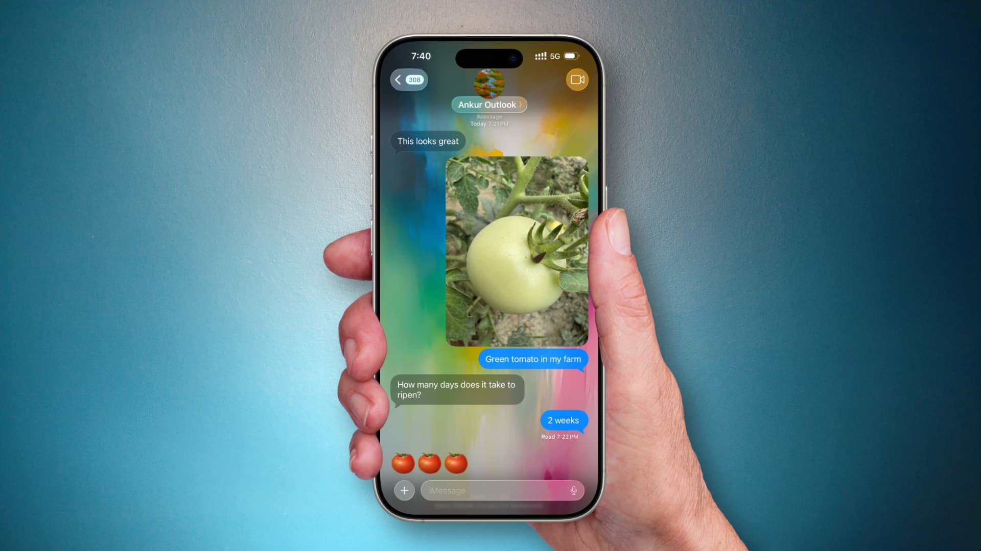 من موقع فون إسلام: يد تحمل هاتفًا ذكيًا يعمل بنظام iOS 26، ويعرض محادثة على iMessage حول طماطم خضراء، مع ظهور خلفيات المحادثات خلف صورة للطماطم ورسائل تناقش وقت نضجها.