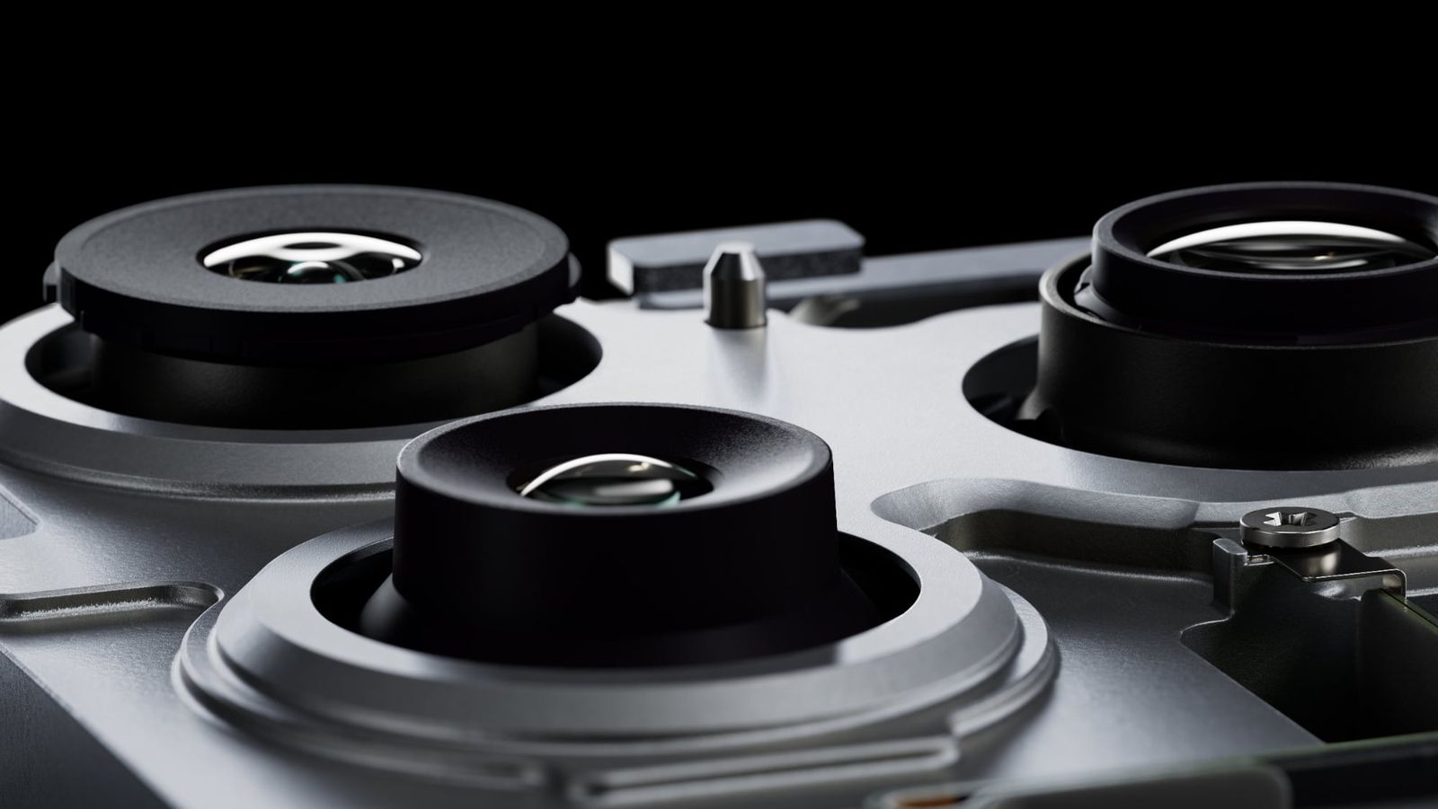 من موقع فون إسلام: منظر عن قرب لثلاث عدسات كاميرا على هيكل هاتف ذكي معدني يظهر عناصر العدسة التفصيلية والتصميم الأنيق على خلفية سوداء.