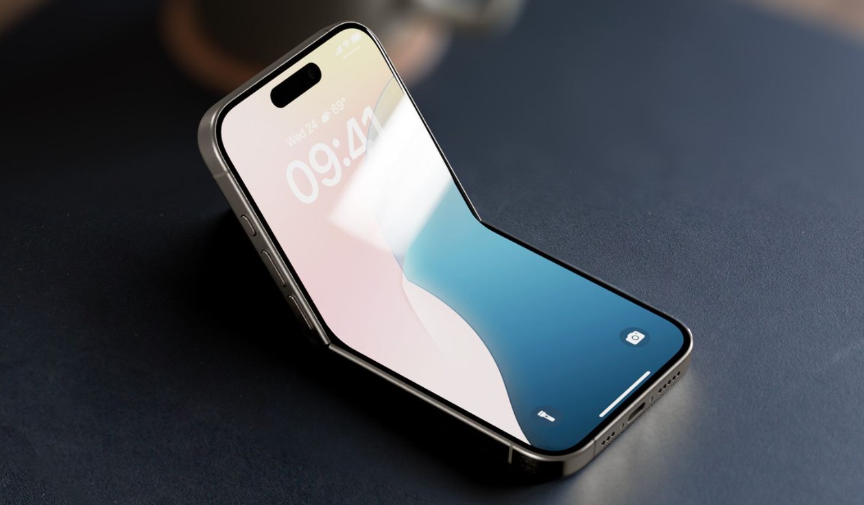 من موقع فون إسلام: يظهر هاتف ذكي بشاشة كبيرة تشبه شاشة عرض كبيرة تشبه الآي-فون القابل للطي مطوية من المنتصف بزاوية مستندة على سطح مظلم.