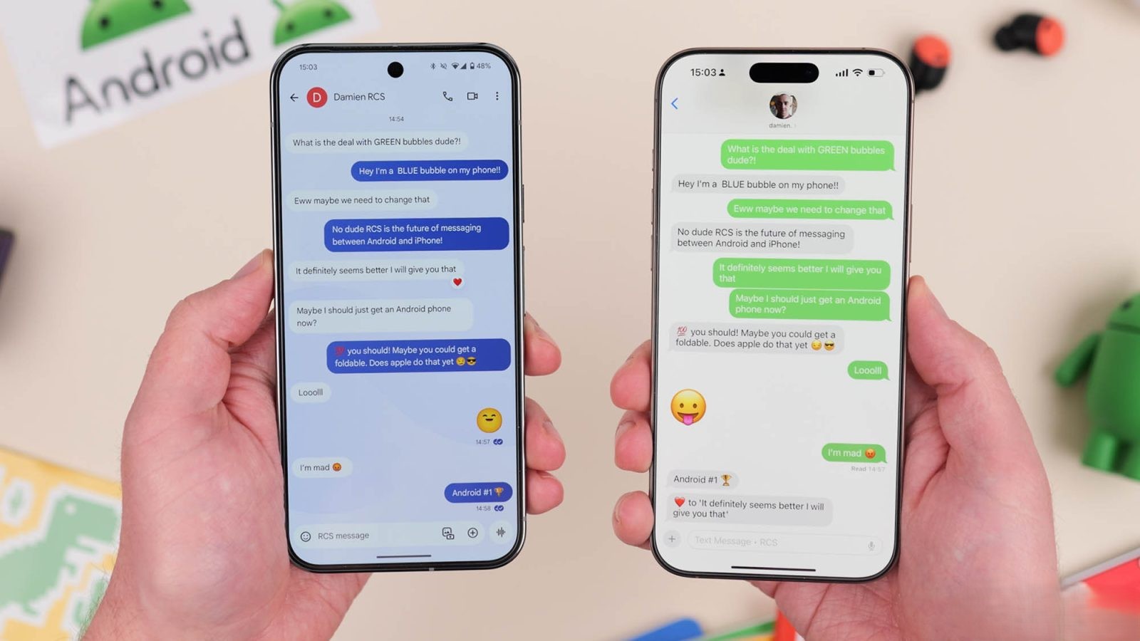 من موقع فون إسلام: يدان تحملان هاتفين ذكيين جنباً إلى جنب؛ يظهر على اليسار فقاعة دردشة زرقاء على جهاز أندرويد مع تشفير RCS، بينما يعرض على اليمين فقاعة دردشة خضراء على جهاز آي آي-فون.