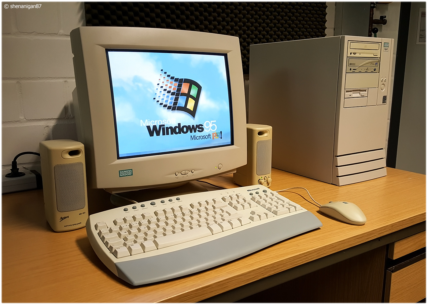 من موقع فون إسلام: يعرض كمبيوتر مكتبي عتيق مزود بشاشة CRT شاشة بدء تشغيل Windows 95. يشتمل الإعداد على لوحة مفاتيح وماوس ومكبرات صوت ومكبرات صوت وحافظة برجية على مكتب خشبي - مما يثير الحنين إلى الماضي على غرار مشهد فيديو نادر عن عودة آبل مع ستيف جوبز.