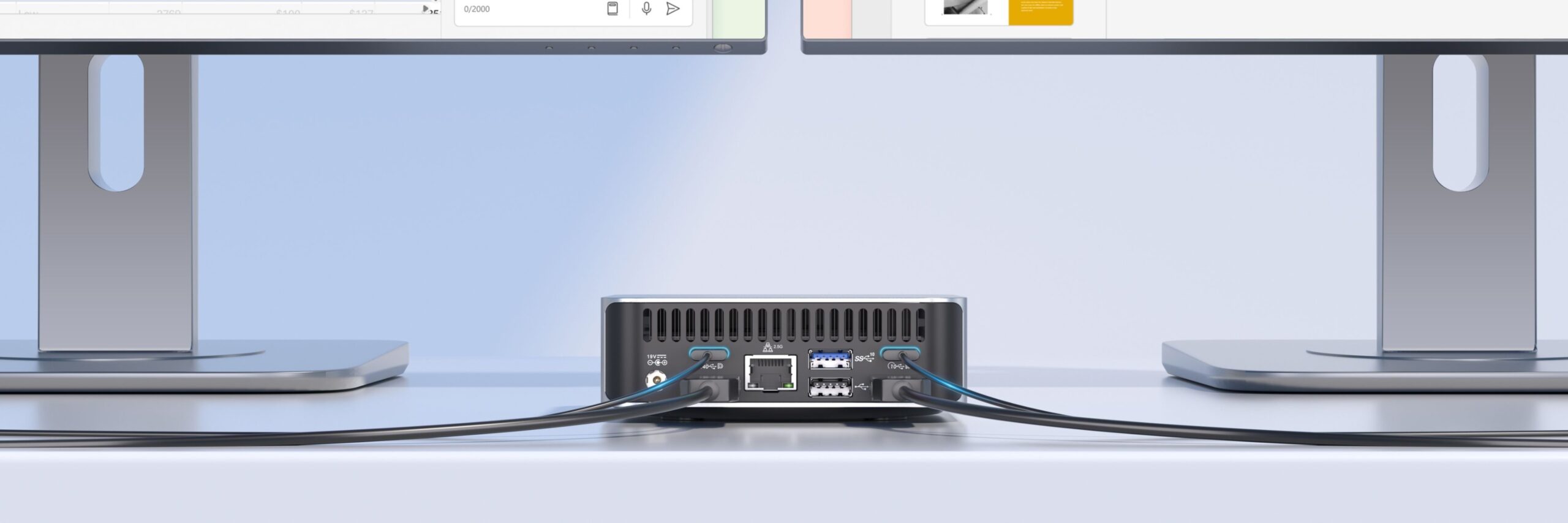 من موقع فون إسلام: يتم وضع جهاز GEEKOM A6 كمبيوتر كمبيوتر ويندوز صغير الحجم بين شاشتين، مع توصيل عدة كابلات بمنافذها الخلفية على مكتب أبيض.