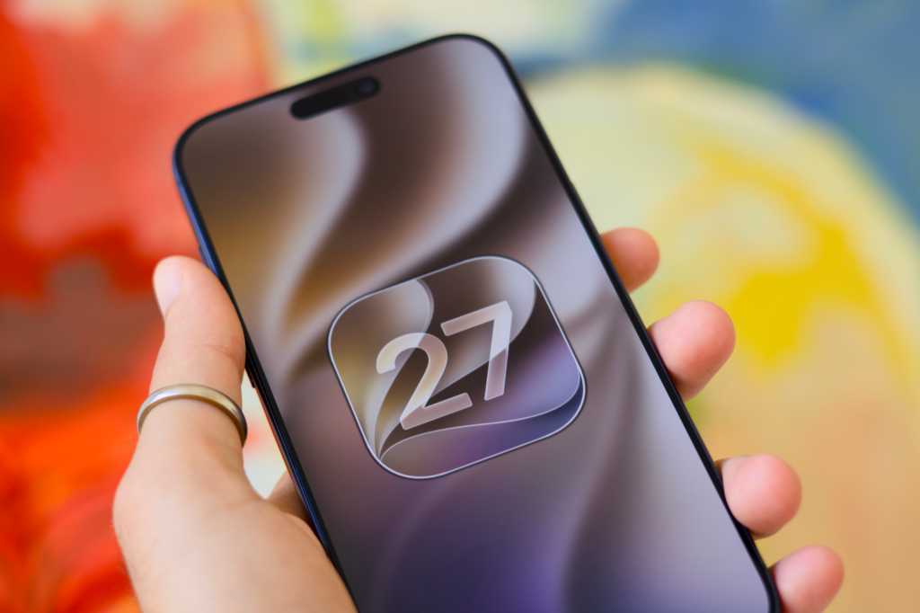 From the Phonegram website: A hand holding a smartphone displaying the number 27 inside a square icon with rounded corners, symbolizing 'hidden iOS 27 features,' against a blurry abstract background.