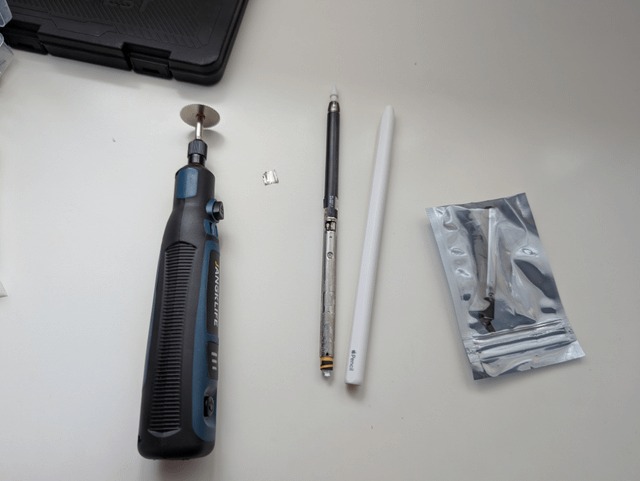 From Phonegram website: A rotary tool, a small metal piece, a scalpel, the new white Apple Pencil, and a metal box containing accessories are shown on a white surface.