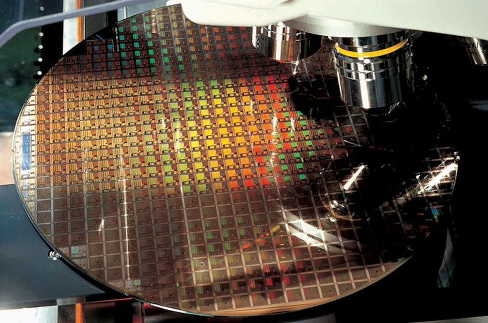 From the Phonegram website: A close-up of a silicon wafer containing small electronic chips being inspected under a microscope, showing the fine details often featured in 'Tech News on the Sidelines' during the week.