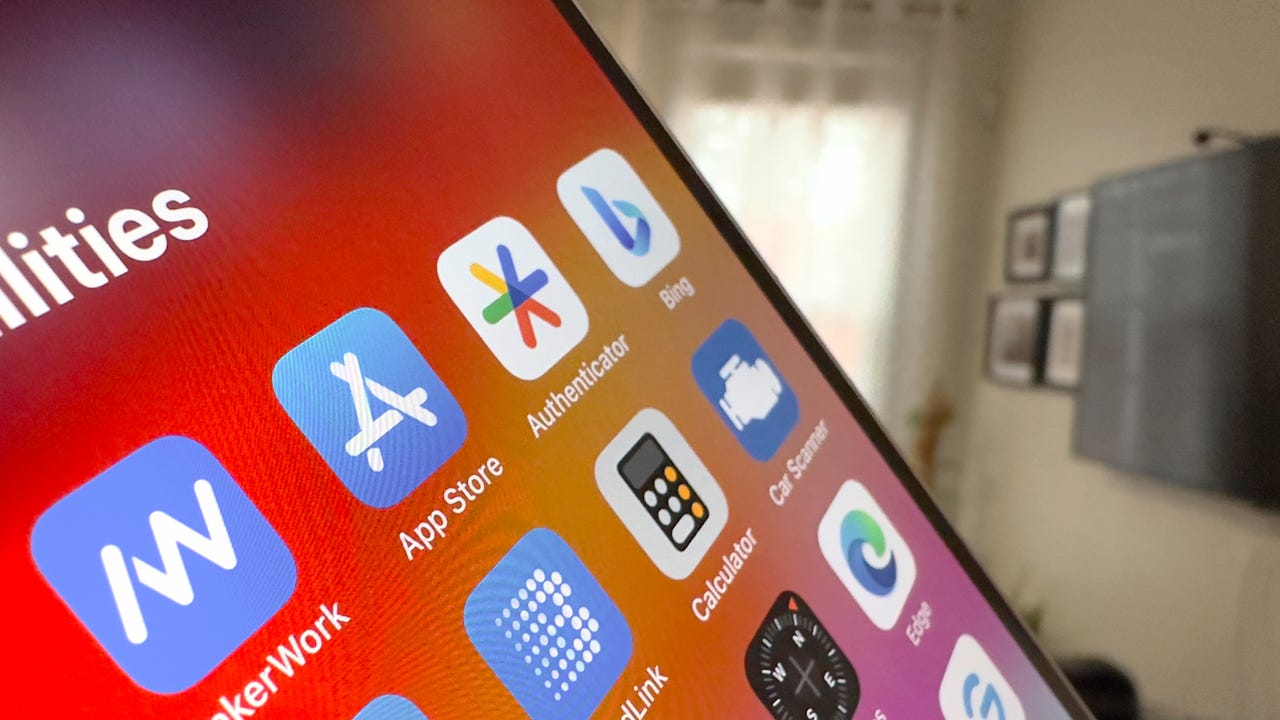 From Phonegram: A close-up of a smartphone screen displaying various app icons, including 'App Store', 'Authenticator', 'Bing', 'Calculator', and 'Car Scanner', against a blurred interior background — highlighting the interface in light of the App Store terms in the European Union.