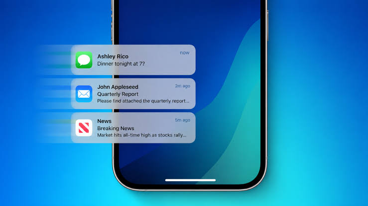 من موقع فون إسلام: لقطة مقربة لهاتف ذكي يعرض ثلاثة إشعارات — تُظهر ميزة «Notify Me» في آي-فون. ومن بين هذه الإشعارات رسالة تتعلق بالعشاء، ورسالة بريد إلكتروني تحتوي على تقرير، وتحديث إخباري عن ارتفاع سوق الأسهم، وكلها معروضة على خلفية زرقاء.