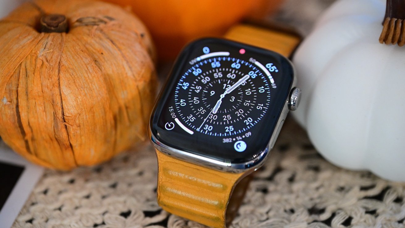 From the Phonegram website: An "Apple Watch" with a digital chronograph face and a light brown leather strap, placed between two decorative orange and white pumpkins in this issue of "Weekly Sidelines".