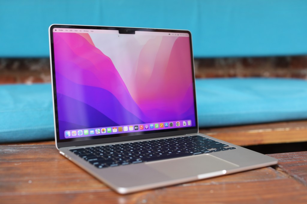 من موقع فون إسلام: جهاز MacBook Pro مفتوح على طاولة خشبية تُعرض عليها ملخص لأخبار الأسبوع.