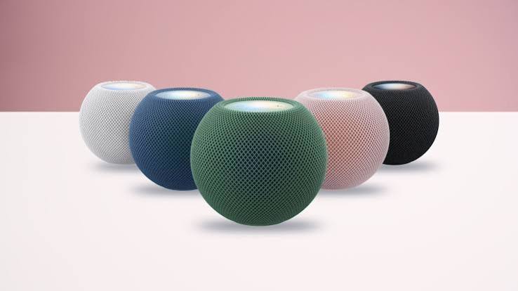 من موقع فون إسلام: خمسة مكبرات صوت ذكية من طراز HomePod mini 2 ذات شكل كروي، باللون الأبيض والأزرق والأخضر والوردي والأسود، مرتبة في شكل نصف دائرة.