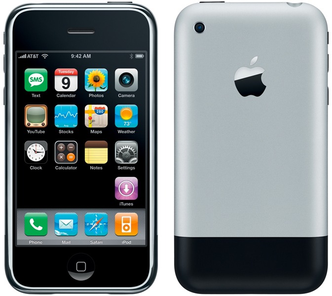 من موقع فون إسلام: منظر أمامي وخلفي لجهاز آيفون من الجيل الأول يعمل بنظام التشغيل iPhone OS 1، يظهر تطبيقات الشاشة الرئيسية وشعار شركة آبل.