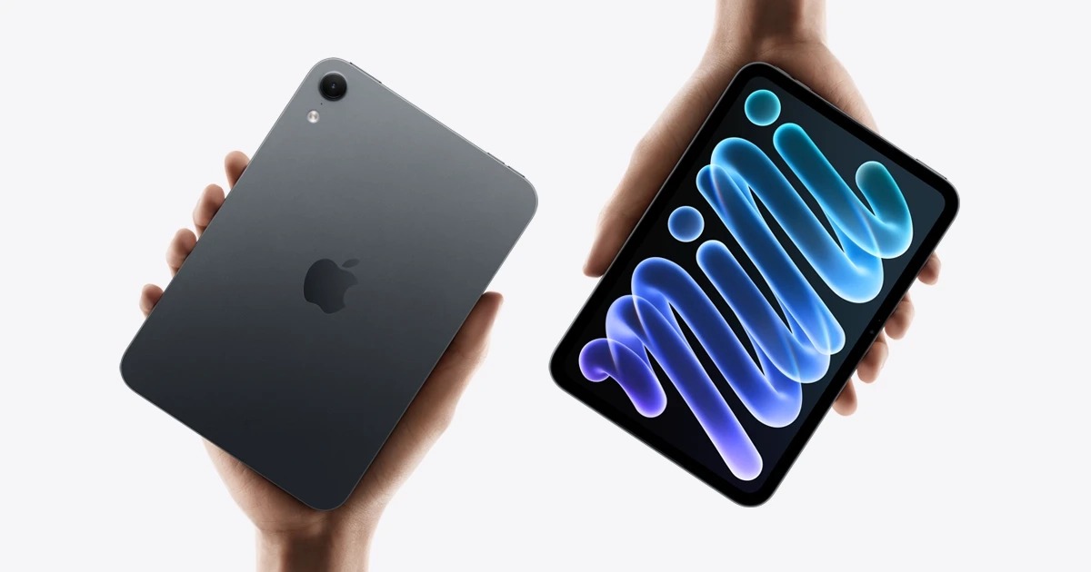 من موقع فون إسلام: يدان تحملان جهاز iPad mini الجديد، تظهران الجزء الخلفي الرمادي للجهاز على اليسار، والشاشة التي تعرض رسمًا تجريديًا أزرق اللون على اليمين.
